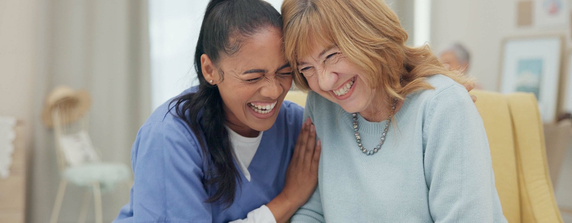 Two ladies sharing a hug laughing