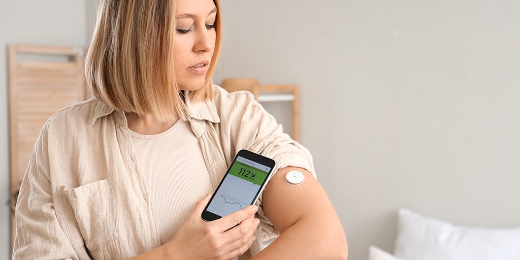 Woman checking continuous glucsoe moniter (CGM)